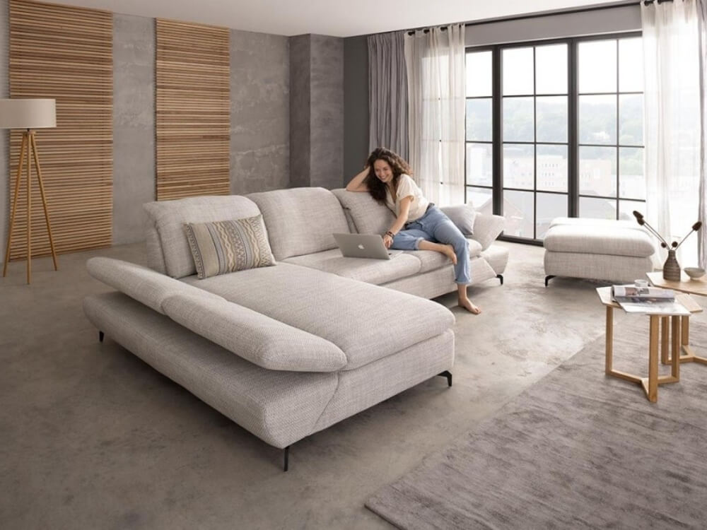 Žena pracujúca na notebooku na sedačke.