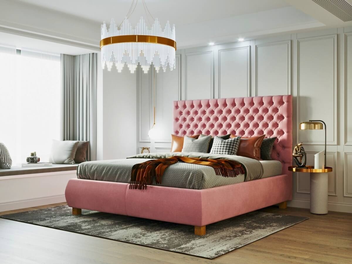 Čalúnená posteľ s veľkým lustrom a zlatými lampami na nočných stolíkoch.